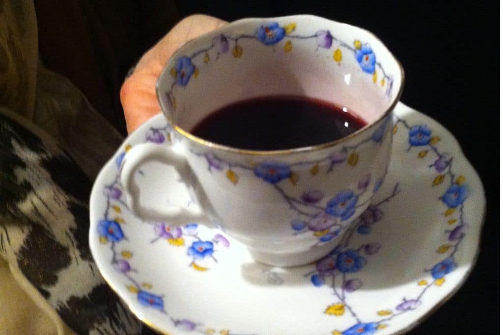 china tea cup filled with dark grape juice