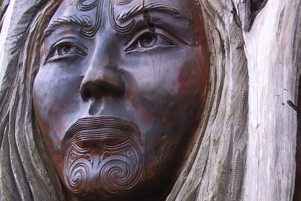 wooden carving of maori female face